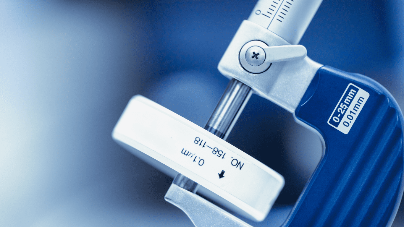 Blaues Bügelmessschraube misst präzises Bauteil – Symbolbild für das Spannungsfeld Toleranzen vs. Funktion.